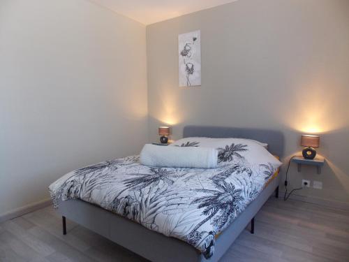 a bed in a room with two lamps on it at Maison de vacances "Le Longchamp" in Osenbach