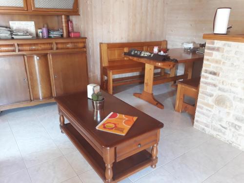 a living room with wooden furniture and a table at La maison neuve in Fontaines