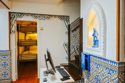 a room with a desk with a computer and a mirror at Help Yourself Hostels - Restelo in Lisbon