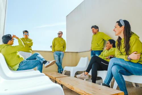 a group of people sitting in chairs in a room at Help Yourself Hostels - Restelo in Lisbon