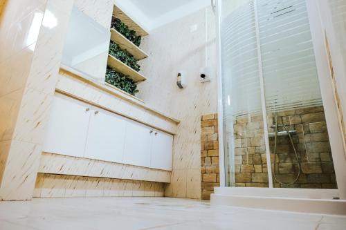 um banheiro com chuveiro e porta de vidro em Help Yourself Hostels - Restelo em Lisboa