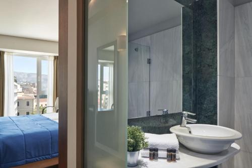 
a bathroom with two sinks and a mirror at Arion Athens Hotel in Athens
