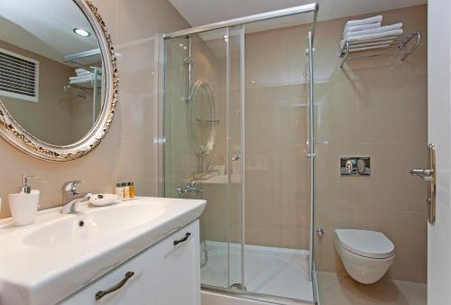 a bathroom with a shower and a sink and a toilet at The Room Hotel & Apartments in Antalya