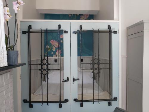 a white cabinet with two glass doors at De Wachtkaemer in De Olde Banck in Stavoren