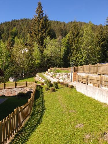 a fence next to a yard with a field of grass at Obereggen - Anna in Eggen