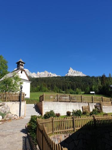 a wooden fence with a church in the background at Obereggen - Anna in Eggen