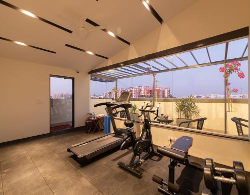 a gym with cardio equipment and a large window at Mojatel By Icon in Bengaluru