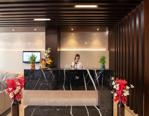 a woman talking on a cell phone in a lobby at Mojatel By Icon in Bengaluru