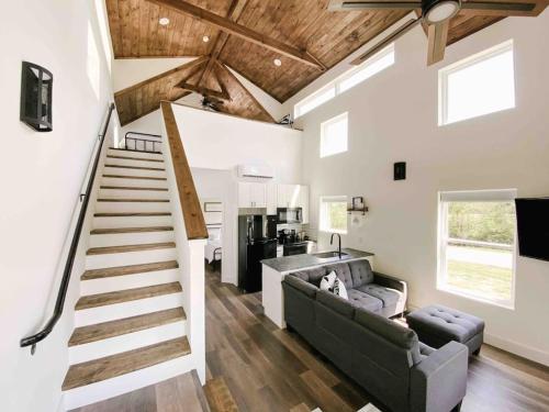 a living room with a staircase and a couch at Cozy Smoky Mountain Tiny House in Pigeon Forge