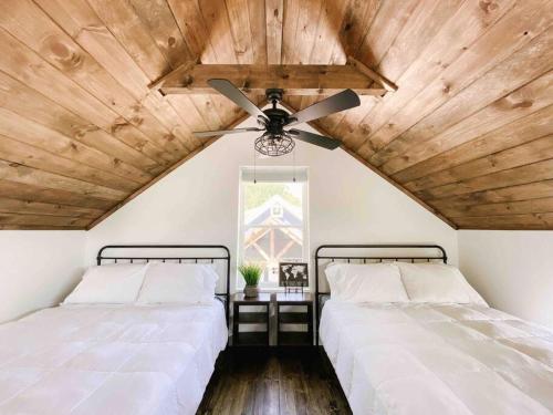 2 camas en una habitación con ventilador de techo en Cozy Smoky Mountain Tiny House, en Pigeon Forge