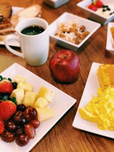 a table with plates of fruit and a cup of coffee at Hyatt Place Columbus-North in Columbus