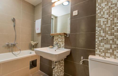 a bathroom with a sink and a tub and a toilet at Lavender Bay Apartment E7 in Donji Morinj