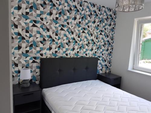 ein Schlafzimmer mit einem Bett und einer geometrischen Wand in der Unterkunft Le petit Wachipré in Rochehaut