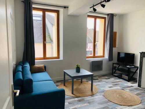 sala de estar con sofá azul y mesa en L’Apparté, en La Roche-Guyon