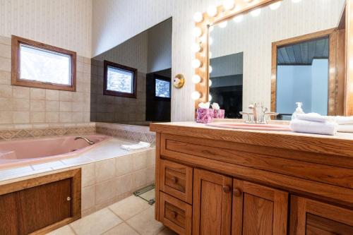 bagno con vasca e grande specchio di Meadow Creek Townhome by Vail Realty a Vail