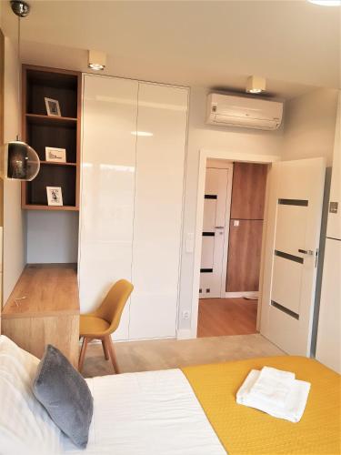 a bedroom with a bed and a desk and a chair at Apartament enjoy! Gdańsk Old Town in Gdańsk