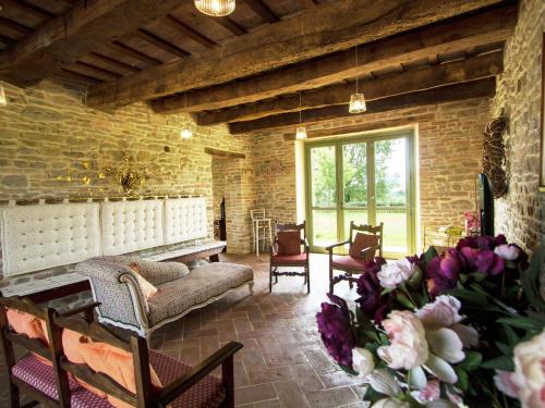 sala de estar con sofá, sillas y flores en Belvilla by OYO Villa Fiorini, en Barchi