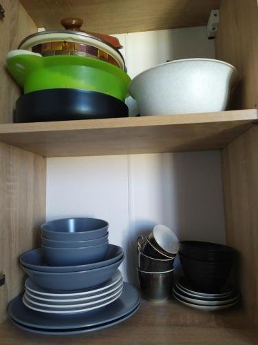 a shelf with plates and bowls and other kitchen utensils at Апартаменти Світлий Ранок та Затишний Вечір in Rivne