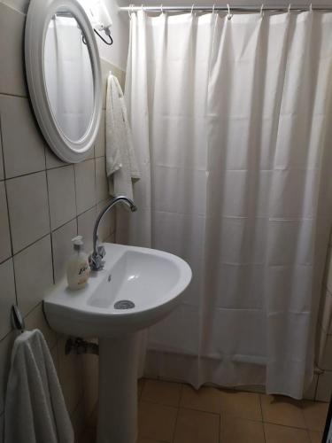a bathroom with a sink and a shower curtain at Kalymnos residence in Kalymnos