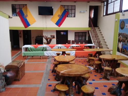 a room with tables and chairs and a staircase at Kucha Wasi Hosteria in San Antonio