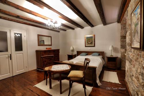 a bedroom with a bed and a table and chairs at Old town house in Pag
