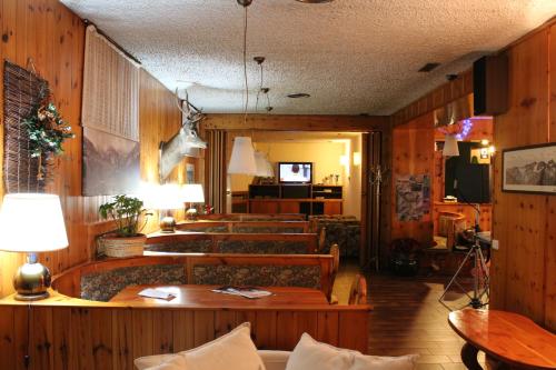 a living room with wooden walls and tables and benches at Hotel Nazionale in Bormio