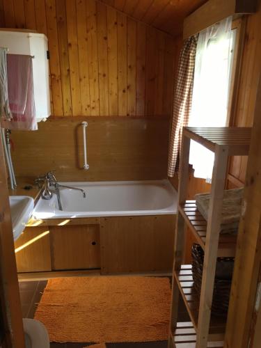 a bathroom with a bath tub and a sink at Chata Strmá in Jeseník