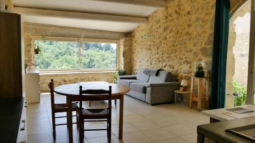 ein Wohnzimmer mit einem Tisch und einem Sofa in der Unterkunft Entre Terre et Ciel in Mazan
