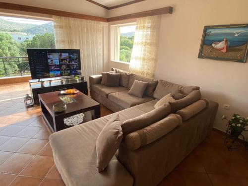 a living room with a couch and a table at Athenian Riviera Family House in Palaia Fokaia