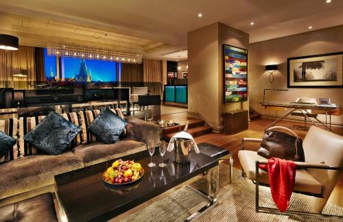 a living room filled with furniture and a tv at The Grand Mark Prague - The Leading Hotels of the World in Prague