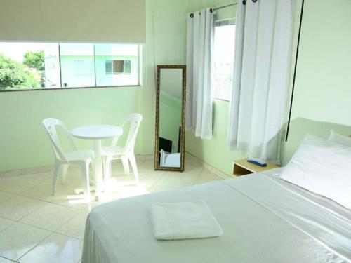 a bedroom with a bed and a table and chairs at Hotel Mais in Macapá