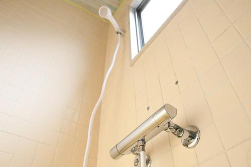 a shower in a bathroom with a shower head at Onsen Inn Hamayu Nagi - Vacation STAY 81905 in Beppu