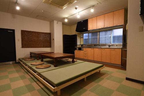 a kitchen with a table and a bench in it at Onsen Inn Hamayu Nagi - Vacation STAY 81905 in Beppu