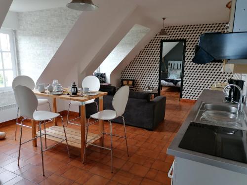 une cuisine et un salon avec une table et des chaises dans l'établissement Gîte 4 pers proche plage avec jardin, à Clohars-Carnoët