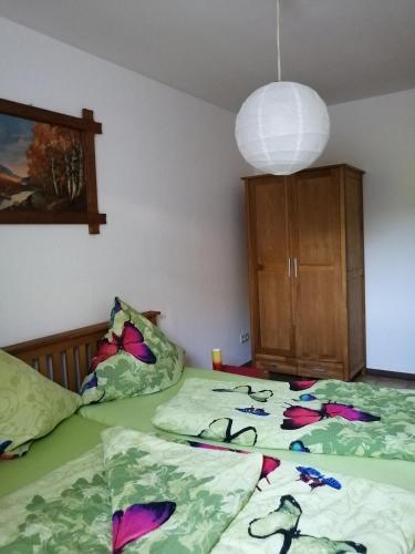 a bedroom with two beds with green sheets and a lamp at Haus Waldeck in Dasburg