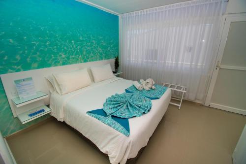 a bedroom with a bed with a teddy bear on it at Hotel San Luis Place By Dorado in San Andrés