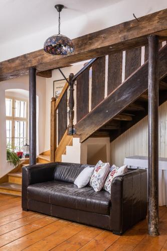 a living room with a black couch and a wooden floor at Penzion Nostalgia in Banská Štiavnica