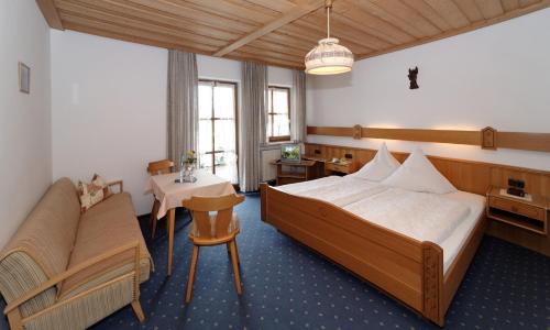 AchslachにあるGasthof-Pension-Krausのベッドとテーブルが備わるホテルルームです。
