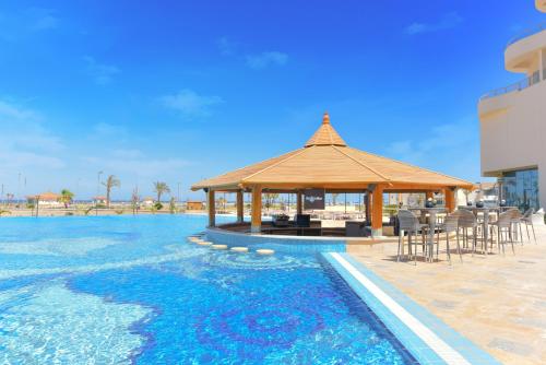 
a beach with a pool and a balcony at Tolip Resort El Galala Majestic in Ain Sokhna
