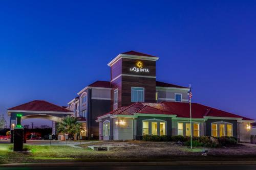 a hotel with a sign on top of a building at La Quinta by Wyndham Kerrville in Kerrville