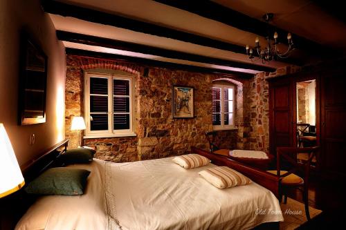 a bedroom with a bed and a stone wall at Old town house in Pag