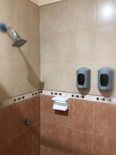 a bathroom with two urinals and a shower at Hotel Paraiso Huasteco in Tamazunchale