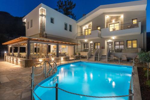 a villa with a swimming pool in front of a house at Oli Terra in Skala Potamias