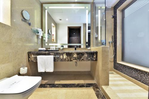 a bathroom with a sink and a toilet and a mirror at Tolip Resort El Galala Majestic in Ain Sokhna