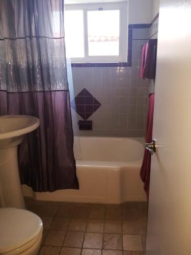 a bathroom with a tub and a toilet and a sink at FAMILY Guayabita's House in Miami