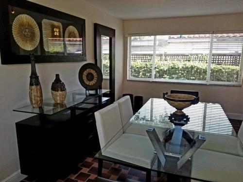 a dining room with a glass table and chairs at FAMILY Guayabita's House in Miami
