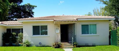 a small white house with a green fence at FAMILY Guayabita's House in Miami