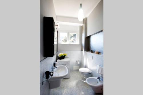 ein Badezimmer mit 2 WCs und einem Waschbecken sowie einem TV in der Unterkunft Dall alba al tramonto in Monterosso al Mare