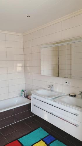 y baño con 2 lavabos, bañera y espejo. en Stadtvilla Lingen, en Lingen