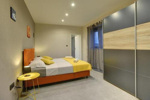 una camera da letto con un letto con una coperta gialla e un tavolo di Villa Nika a Fažana